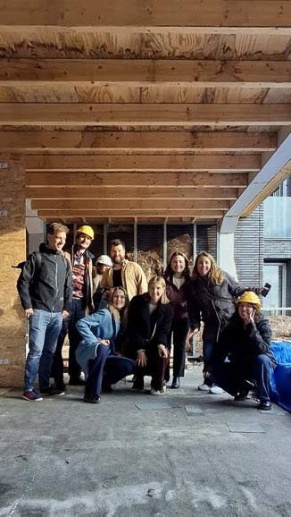 Het team van Studioschaeffer op een bouwlocatie onder een houten balkenlaag