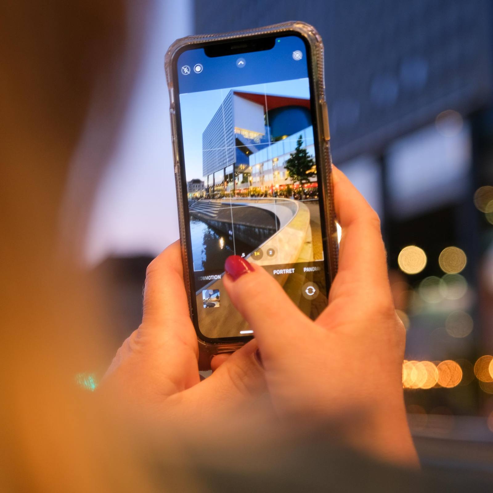 Een smartphone legt een gebouw vast, met de stad onscherp erachter